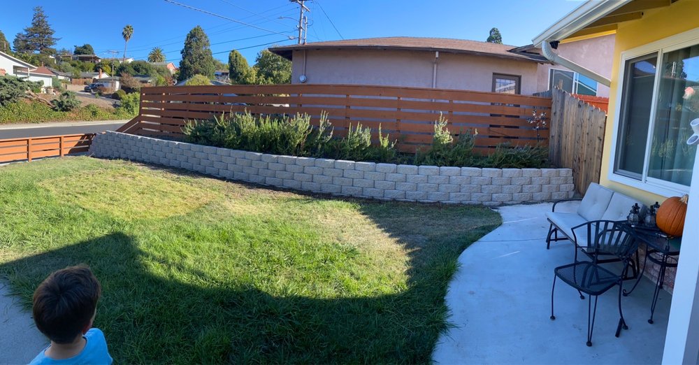 Stone retaining wall with new wood fence